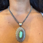 Sterling Silver Necklace with a green turquoise stone pendant on a person's neck - Blanca Flor Silver Jewelry
